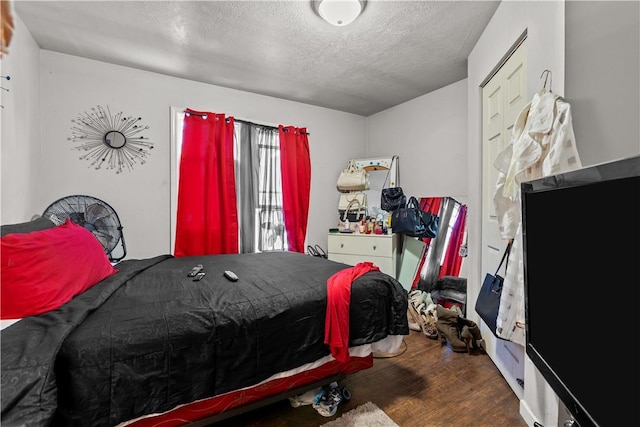 bedroom with a textured ceiling and hardwood / wood-style floors