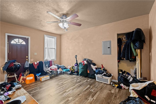 interior space featuring a closet, wood-type flooring, ceiling fan, electric panel, and a textured ceiling