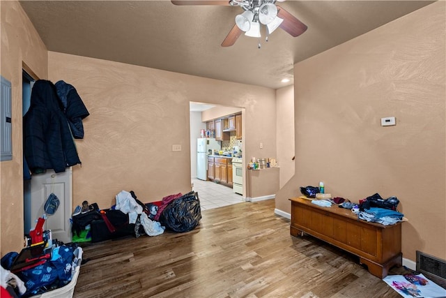 interior space featuring ceiling fan, white fridge, and light hardwood / wood-style flooring