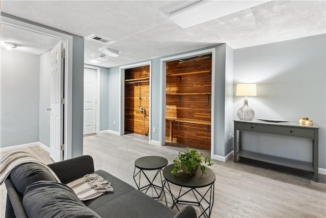 living room featuring a textured ceiling and light hardwood / wood-style flooring