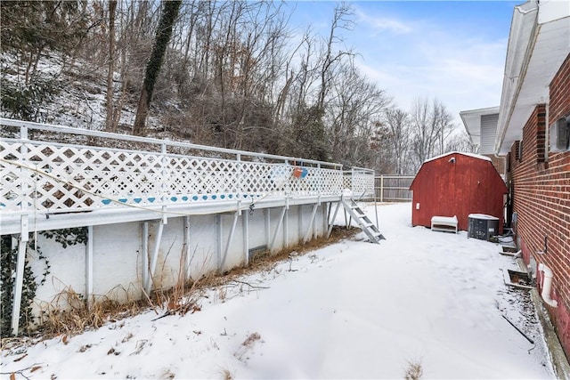 yard layered in snow with central AC and a storage unit