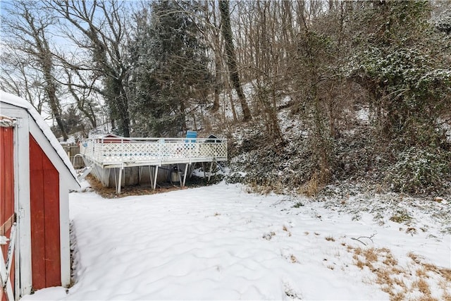 yard covered in snow with a deck