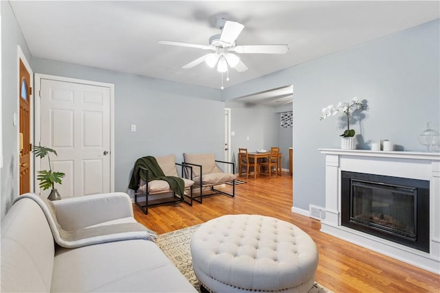 sitting room with ceiling fan and light wood-type flooring