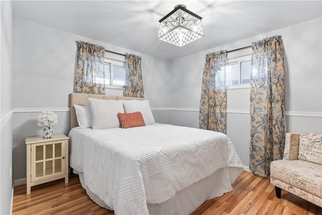 bedroom featuring an inviting chandelier and hardwood / wood-style flooring