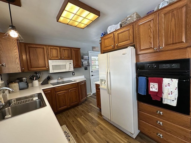 kitchen with sink, black appliances, pendant lighting, and dark hardwood / wood-style floors