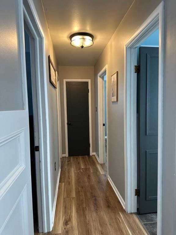 corridor with hardwood / wood-style flooring