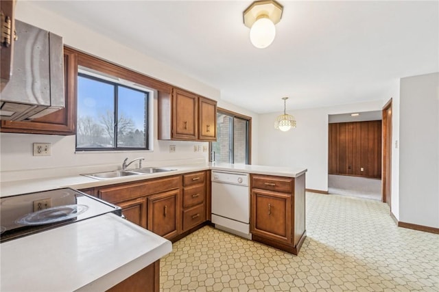 kitchen with white dishwasher, kitchen peninsula, decorative light fixtures, and sink