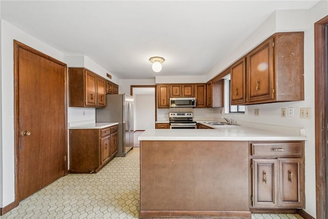 kitchen with kitchen peninsula, appliances with stainless steel finishes, and sink