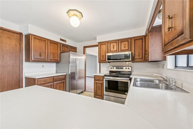 kitchen with kitchen peninsula, stainless steel appliances, and sink