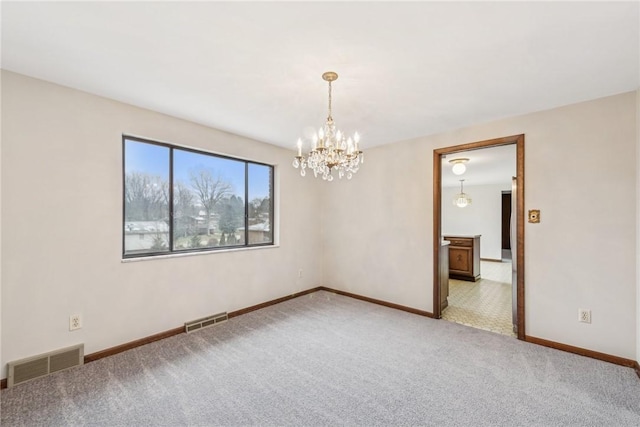 carpeted spare room with a chandelier