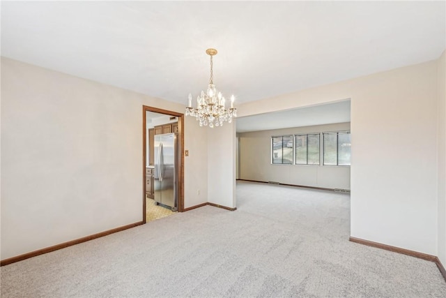 spare room with light colored carpet and a chandelier