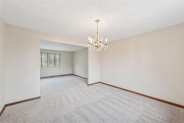 unfurnished room with an inviting chandelier and light colored carpet