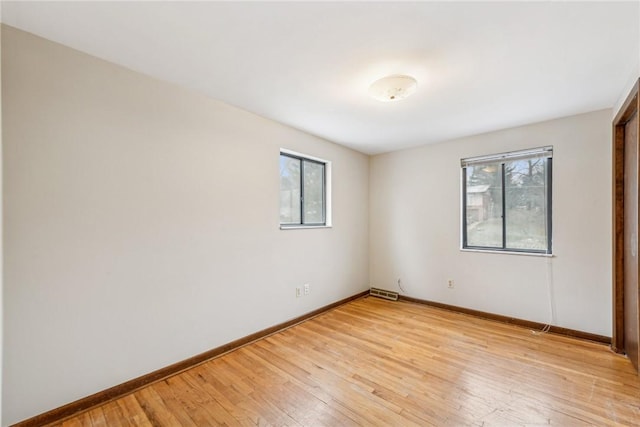 unfurnished room featuring light hardwood / wood-style floors and plenty of natural light