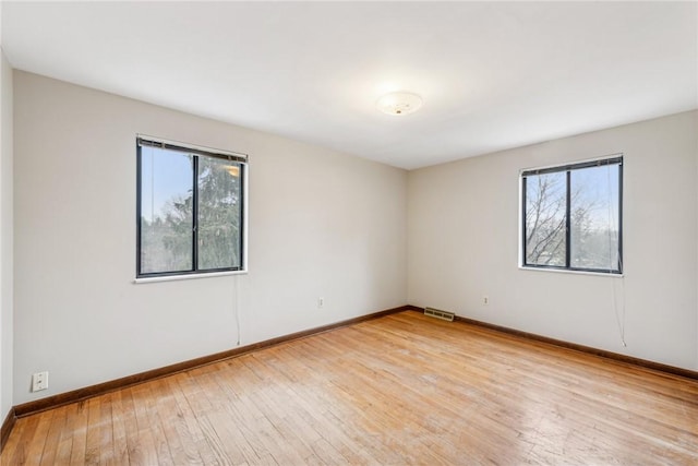 unfurnished room featuring a healthy amount of sunlight and light hardwood / wood-style floors