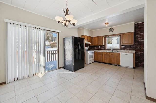 kitchen featuring sink, decorative light fixtures, an inviting chandelier, white appliances, and decorative backsplash