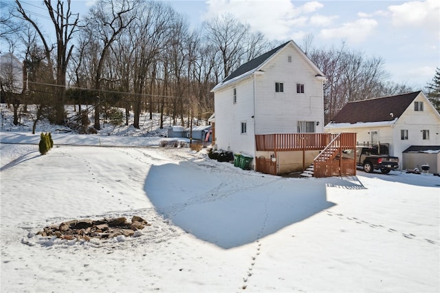 snow covered property with a wooden deck