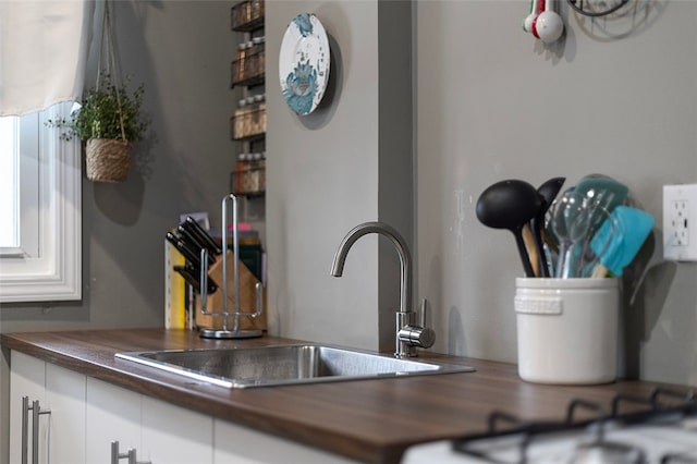 room details featuring white cabinets and sink