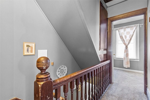 hallway with light colored carpet and vaulted ceiling