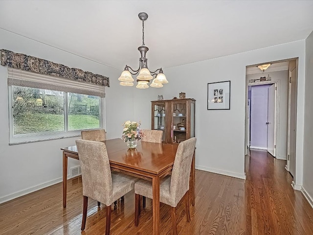 dining space featuring a chandelier and dark wood-type flooring