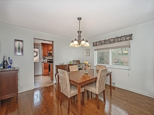 dining room featuring a notable chandelier and dark hardwood / wood-style flooring