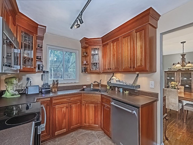 kitchen with sink, rail lighting, a chandelier, pendant lighting, and appliances with stainless steel finishes