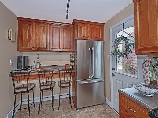 kitchen featuring track lighting, baseboard heating, and high end fridge