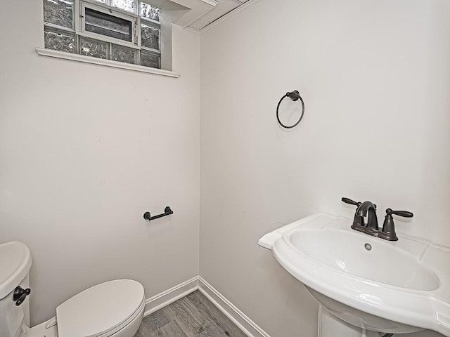 bathroom with toilet, hardwood / wood-style flooring, and sink