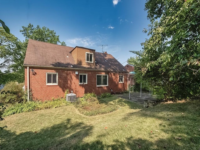 back of house featuring a lawn and central AC unit