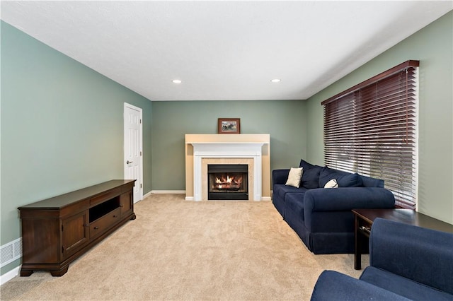 carpeted living room featuring a tiled fireplace