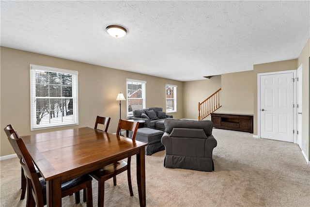 carpeted dining area featuring a textured ceiling