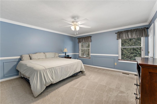 bedroom with ceiling fan, ornamental molding, and light colored carpet