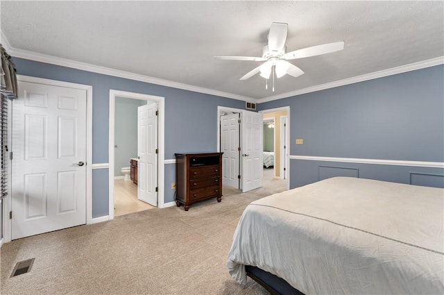 carpeted bedroom featuring ceiling fan, connected bathroom, and crown molding