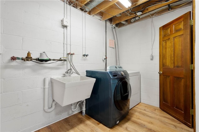 washroom with sink, light hardwood / wood-style flooring, and independent washer and dryer