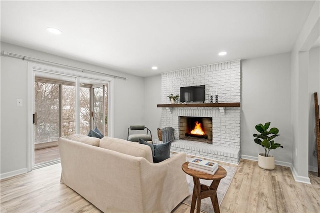 living room featuring light hardwood / wood-style flooring and a fireplace