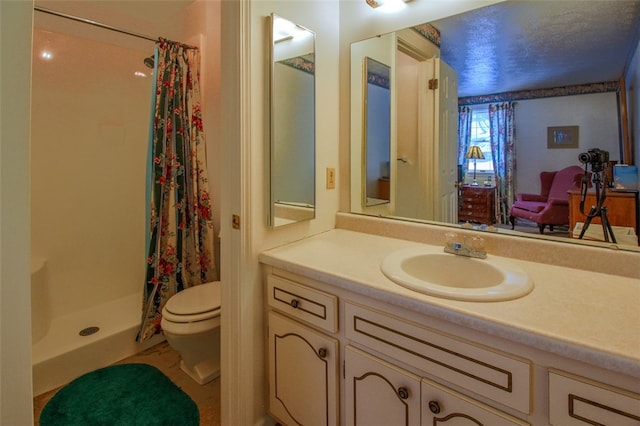 bathroom with curtained shower, vanity, and toilet