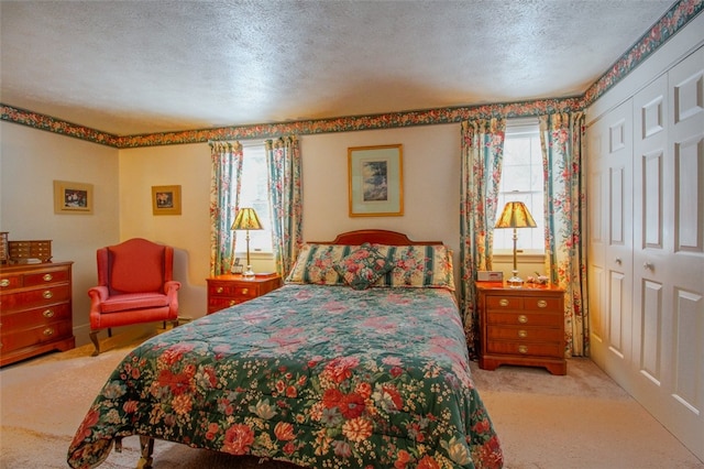 carpeted bedroom with a textured ceiling, a closet, and multiple windows