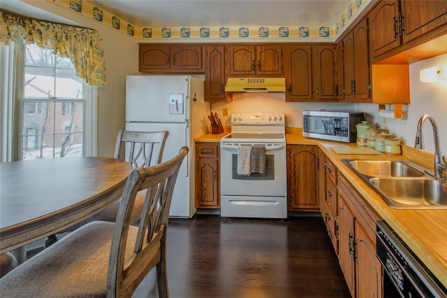 kitchen featuring white appliances, dark wood-type flooring, and sink