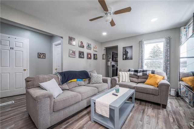 living room featuring ceiling fan and dark hardwood / wood-style floors