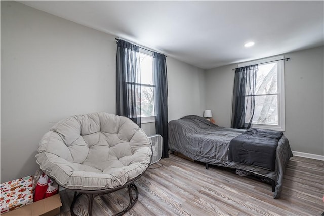 bedroom featuring light hardwood / wood-style flooring and multiple windows