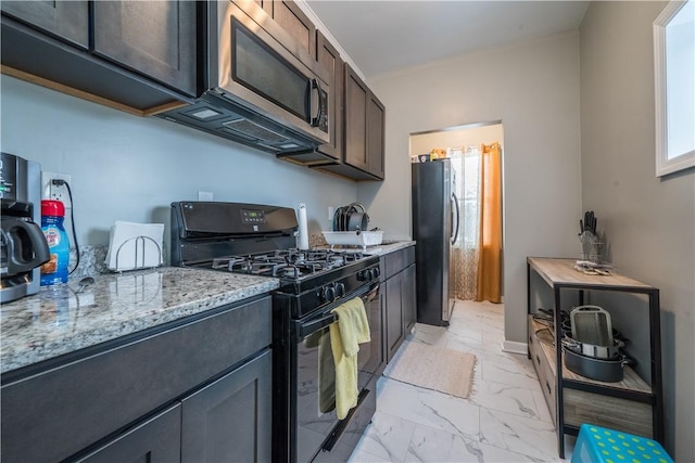 kitchen featuring light stone counters, stainless steel appliances, and dark brown cabinets