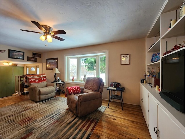 living room with light hardwood / wood-style floors and ceiling fan