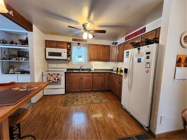 kitchen with white appliances, ceiling fan, dark hardwood / wood-style floors, and sink