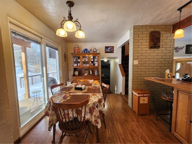 dining room featuring a textured ceiling and dark hardwood / wood-style floors