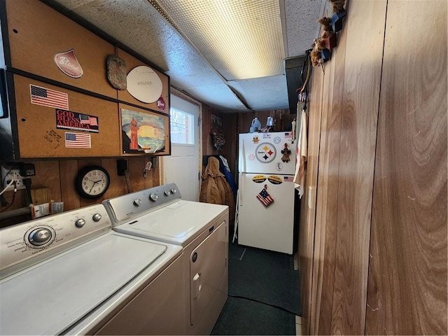 laundry room with washer and dryer and wood walls