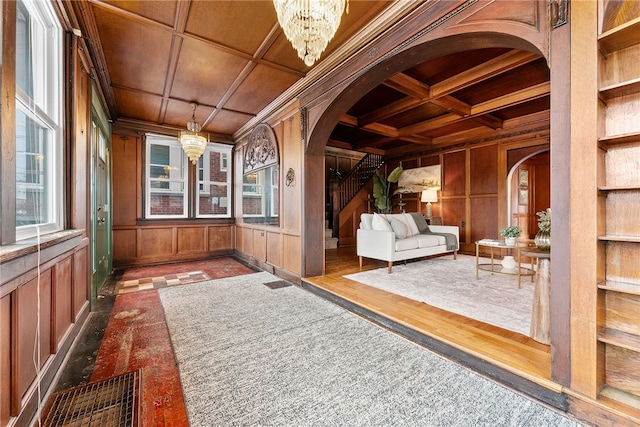 unfurnished sunroom with coffered ceiling, beam ceiling, a notable chandelier, and wooden ceiling