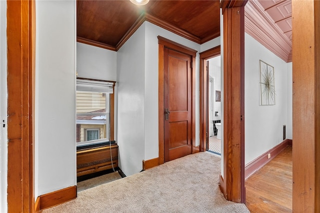 corridor featuring wooden ceiling, light carpet, and ornamental molding