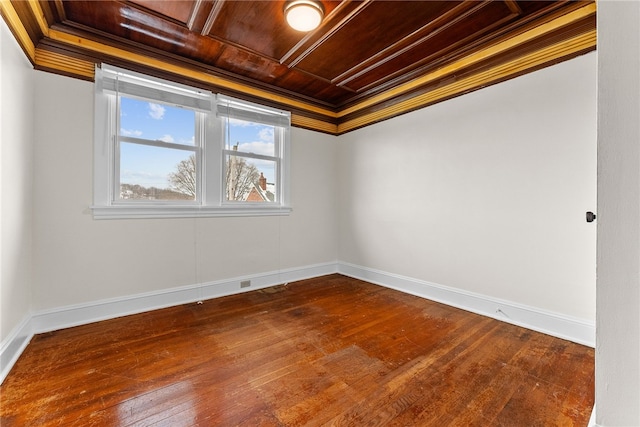 spare room featuring coffered ceiling, hardwood / wood-style floors, crown molding, and wood ceiling