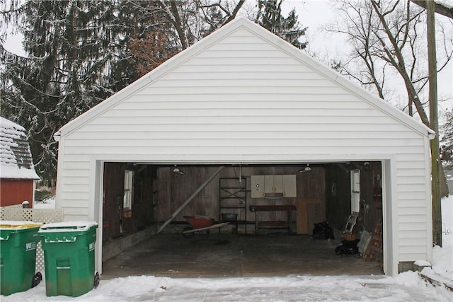 snow covered garage featuring a detached garage