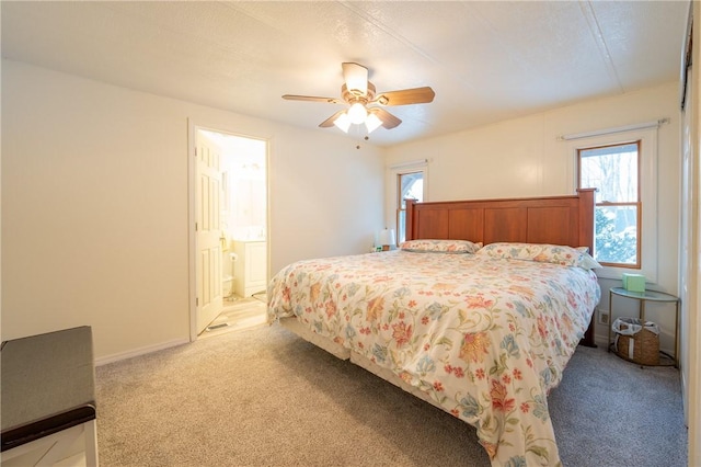 carpeted bedroom with ceiling fan and ensuite bath