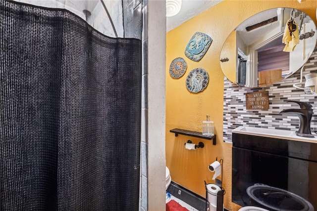 bathroom featuring toilet, vanity, a shower with shower curtain, and decorative backsplash